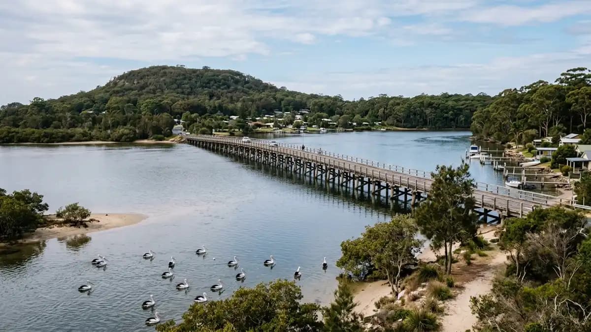 Jimmy's Beach at Hawks Nest with calm water and the Singing Bridge in the background, NSW