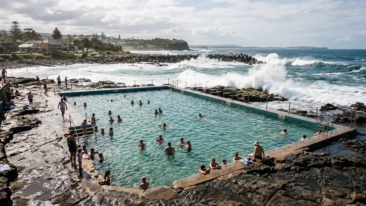 Shellharbour Village rock pool with ocean waves crashing over volcanic rock platform, Illawarra coast NSW