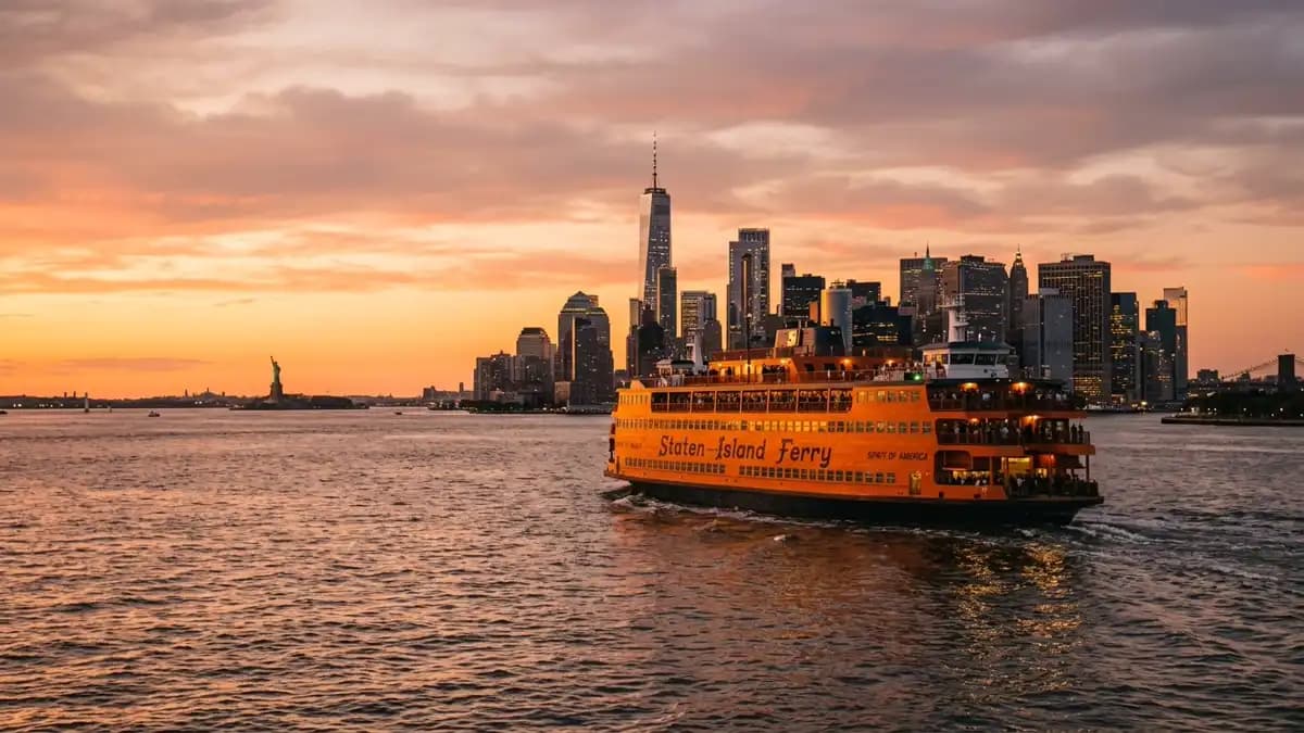 Orange Staten Island Ferry approaching Manhattan at sunset