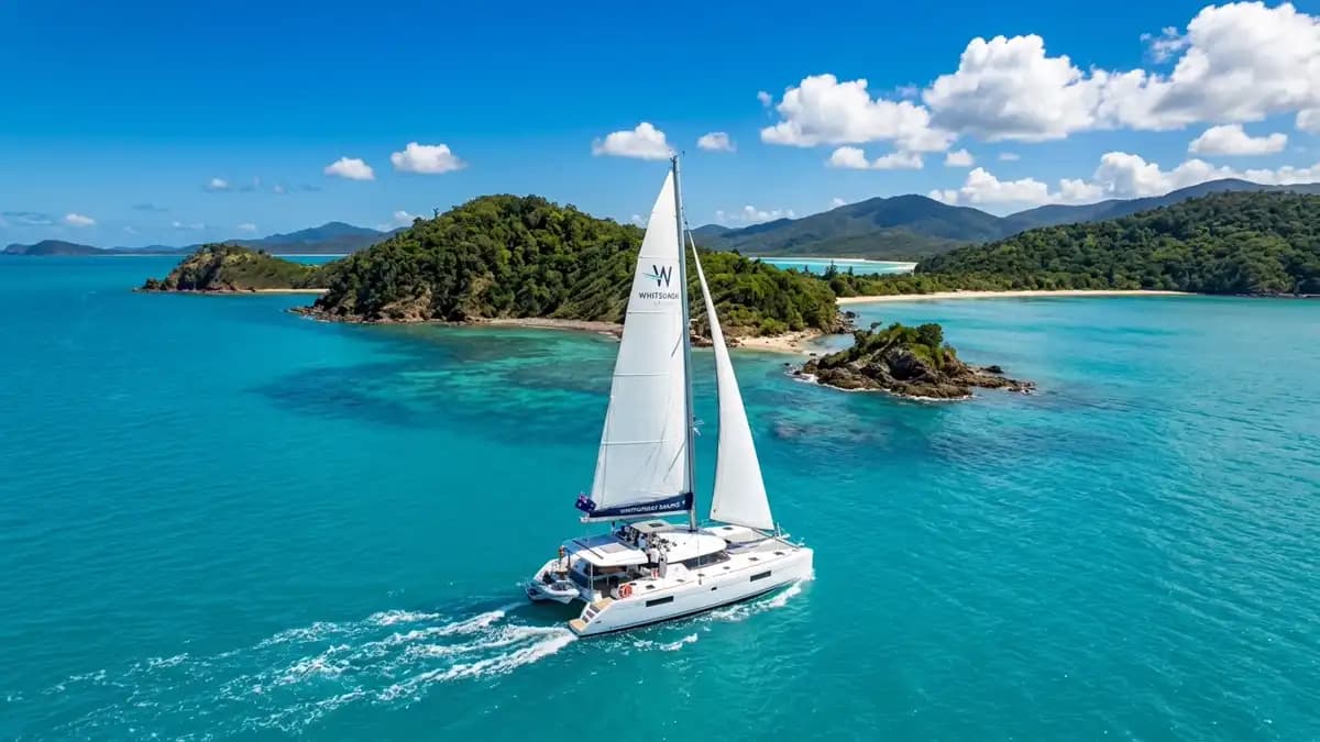 Catamaran sailing through turquoise Whitsunday Islands Queensland