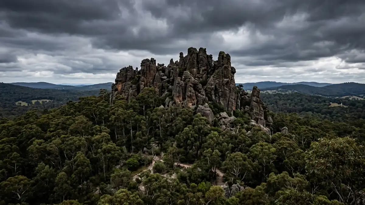 Hanging Rock volcanic formation rising above eucalyptus forest near Woodend, Victoria