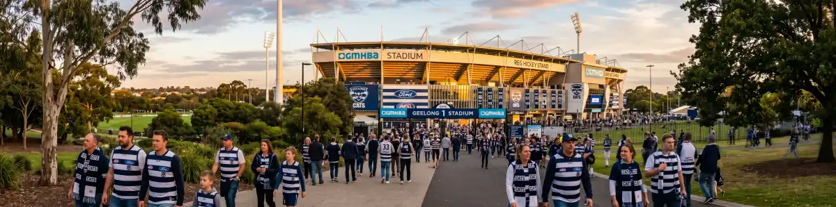GMHBA Stadium Kardinia Park Geelong at golden hour with fans in blue and white walking toward the gates