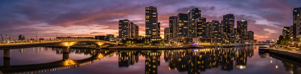Melbourne Docklands waterfront at dusk with modern hotel buildings reflected in the still harbour water