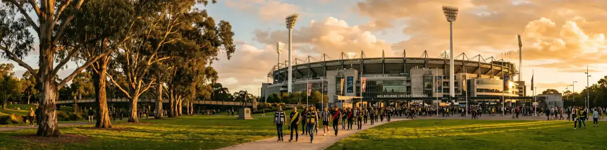 Melbourne Cricket Ground at golden hour with fans walking through Yarra Park toward the stadium gates