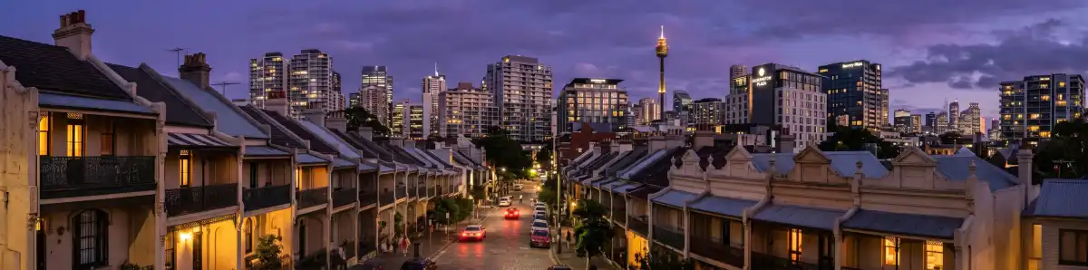 Sydney Eastern Suburbs skyline at dusk with hotel buildings in Surry Hills and Paddington and heritage terrace houses in the foreground